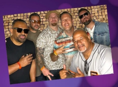 Group of friends celebrating with props and signs at photo booth